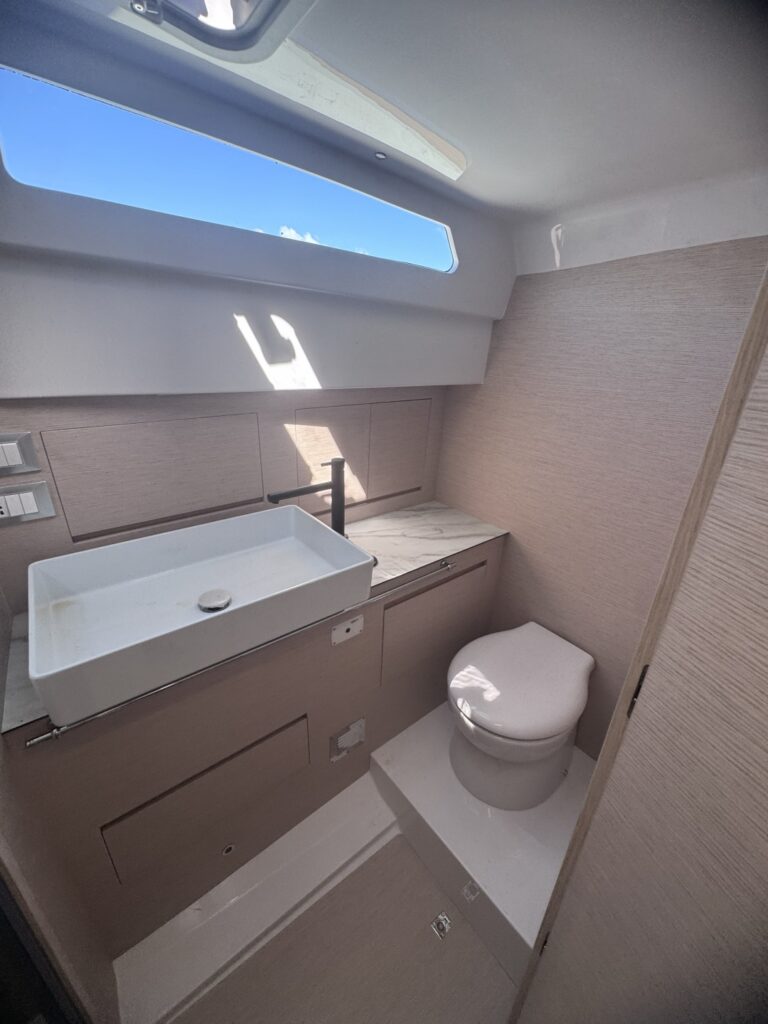 A heads compartment with a basin and a window above