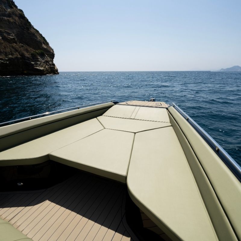 The bow sundeck, a wedge of pale green cushions running to the tip of the tubes