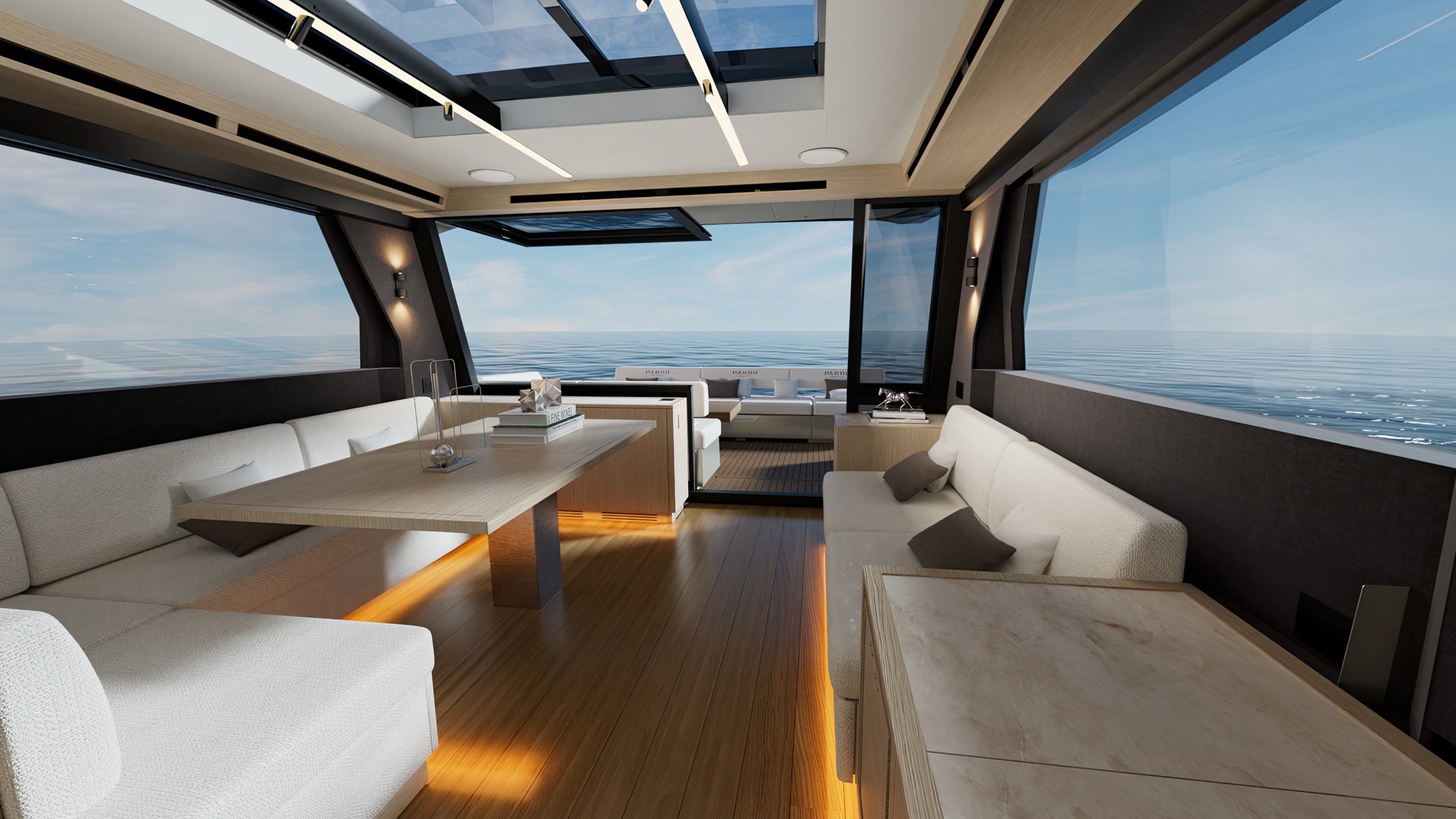 The saloon dining table and seating, with the aft window open to the cockpit