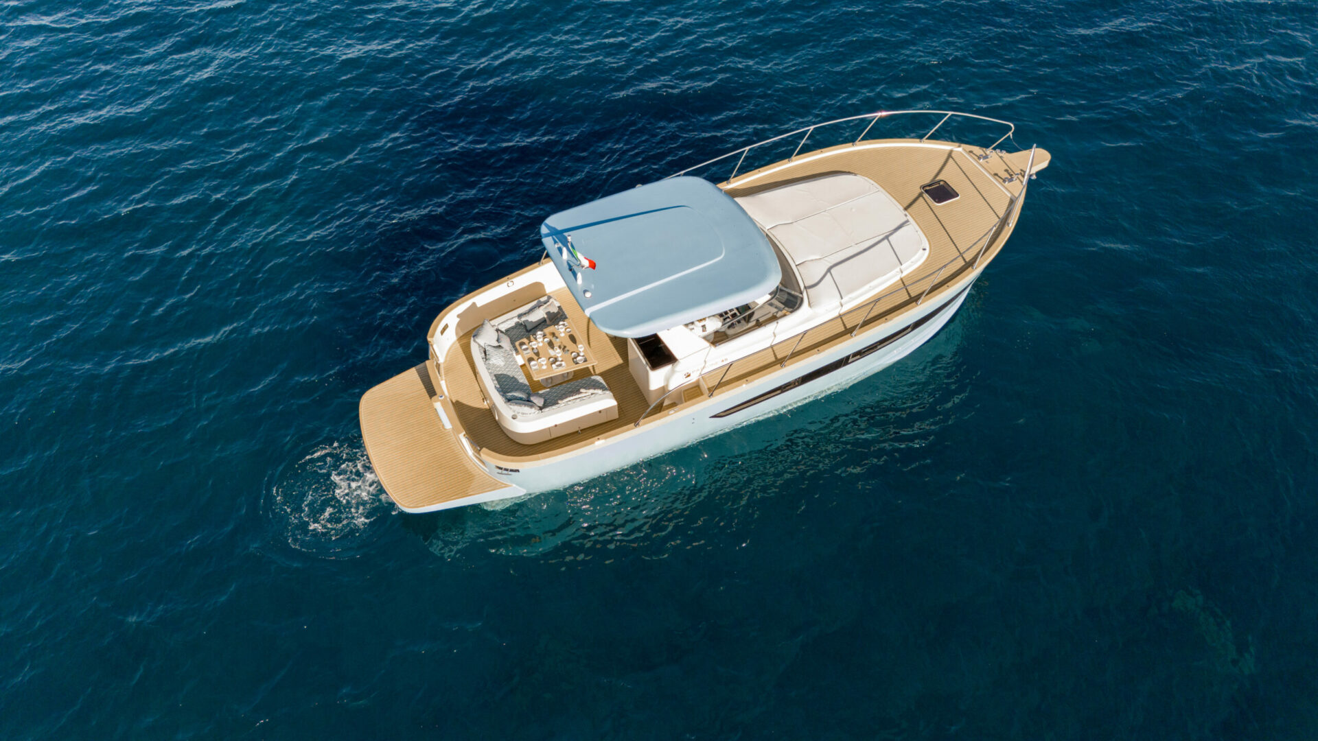 The 45 from above and ahead, showing the foredeck sun pad and the T-top