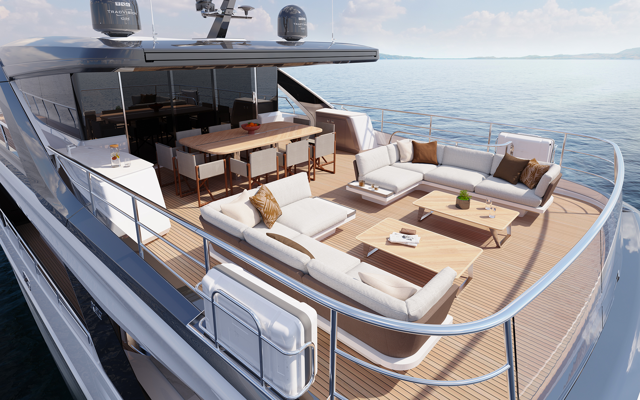 The flybridge seen from above and forward, with a long dining table and chairs under the hardtop, a large corner sofa and sunpads aft, and satellite domes on the arch overhead