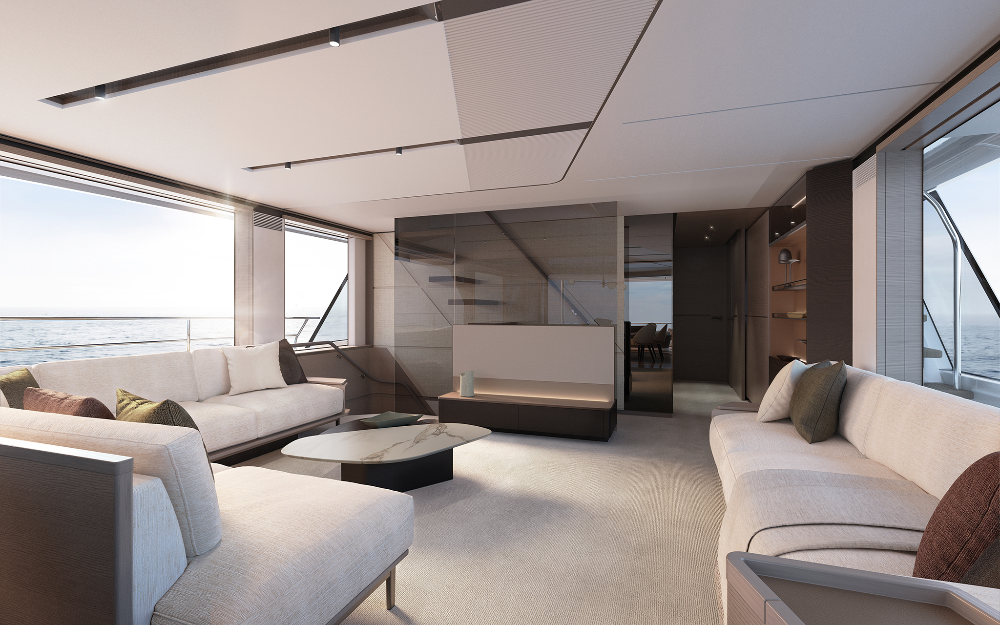 The saloon looking forward, three pale sofas around a white marble low table on a light carpet, full-height windows to port and a smoked-glass staircase screen at the far end