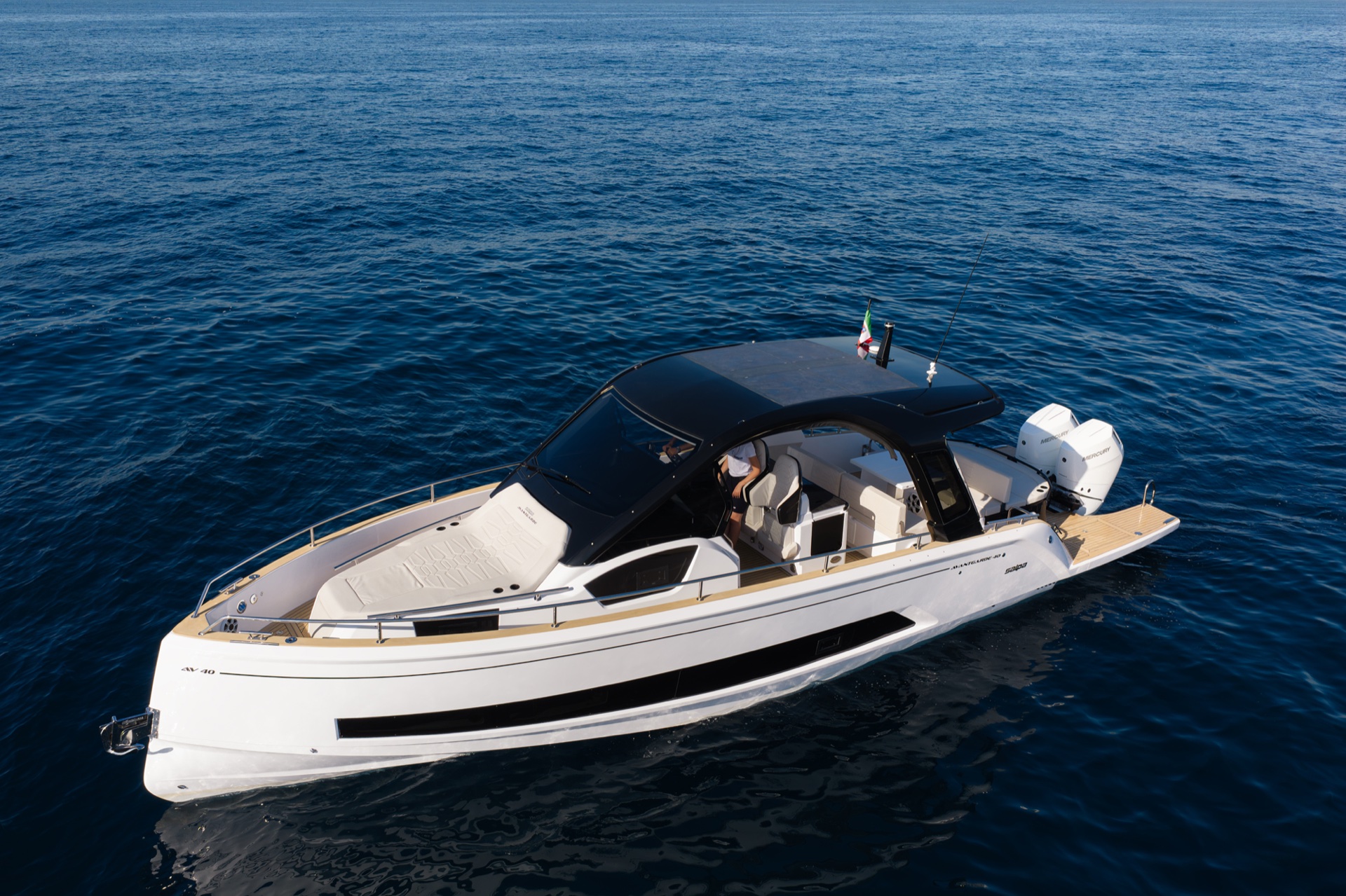 Seen from above on the bow quarter, the forward sunpad ahead of the windscreen and the cockpit under the hard top