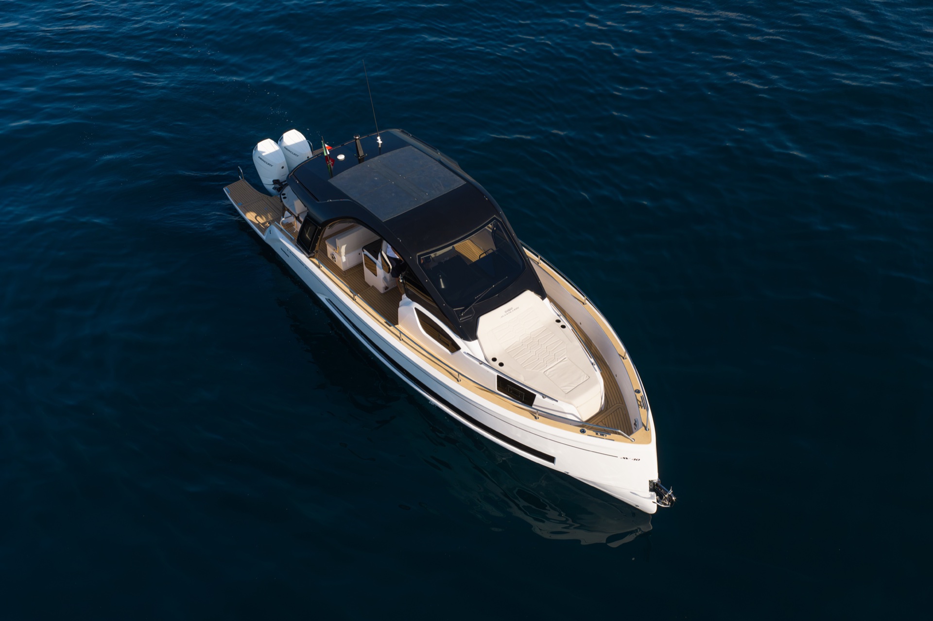 Directly overhead, the teak swim platform, cockpit seating, hard top and foredeck sunpad