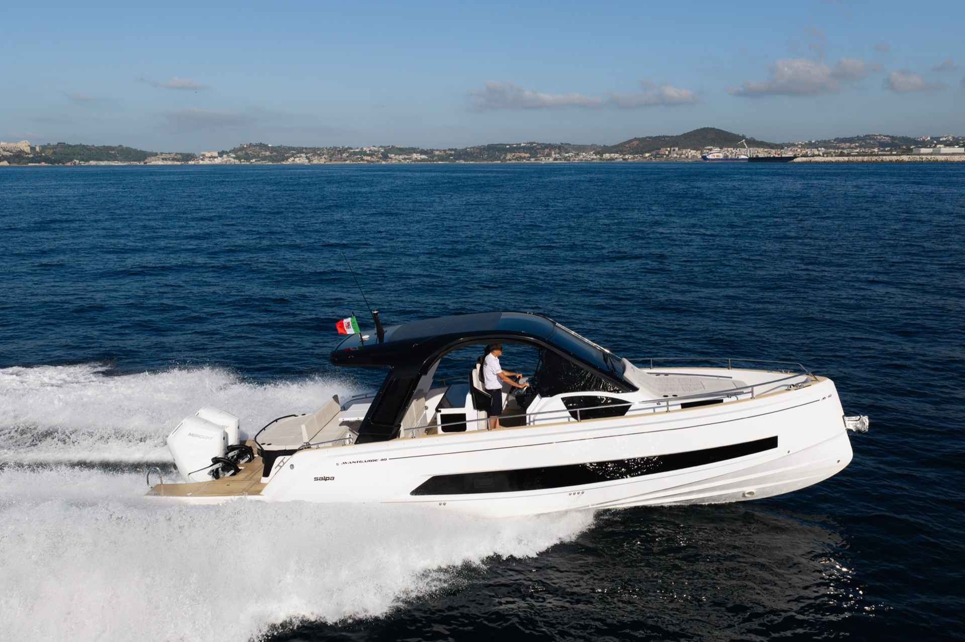 Running at speed, the skipper at the helm under the hard top