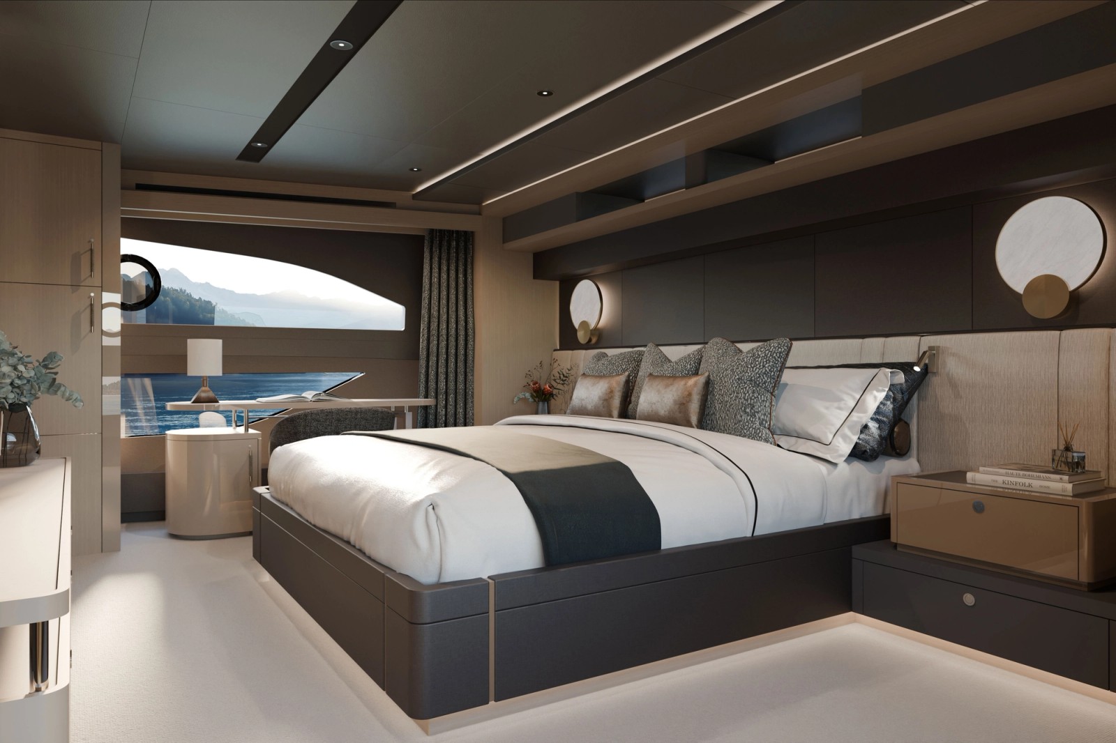 A double cabin with the bed set against a padded headboard, a curved hull window running along one side and a seat beneath it