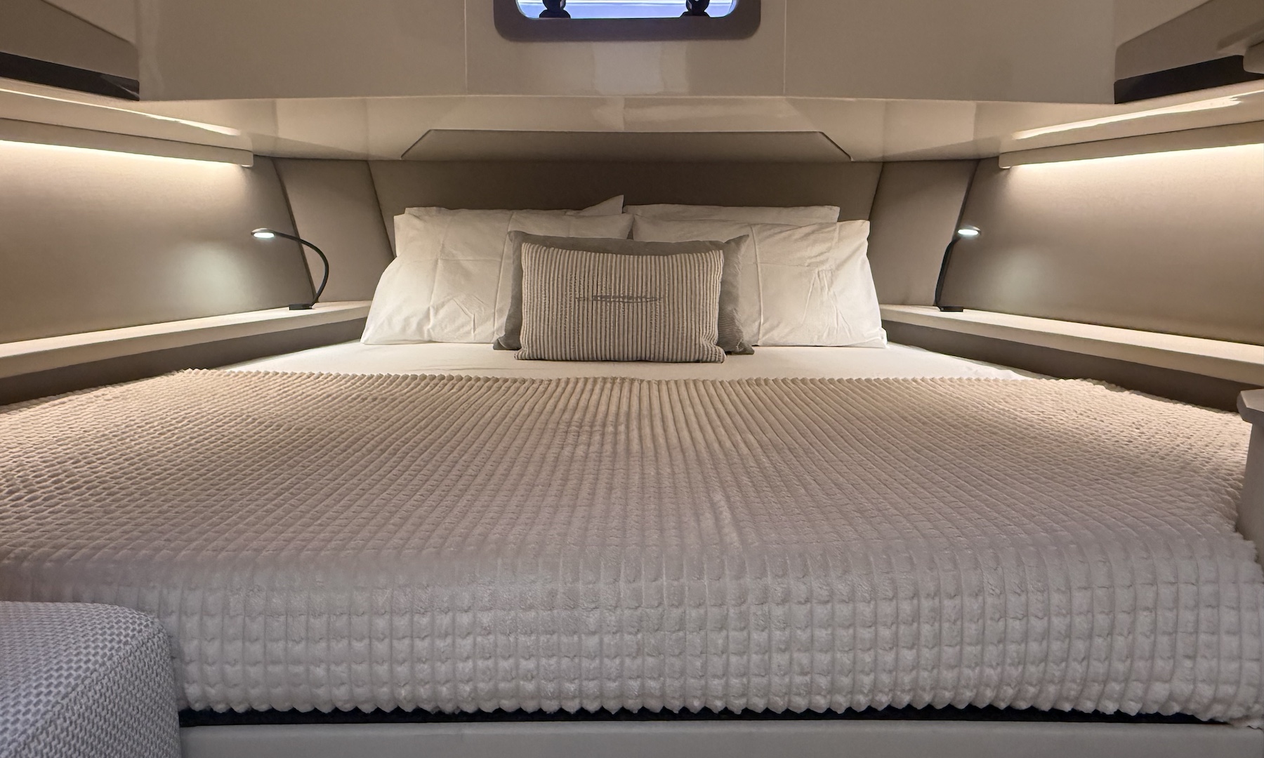 The cabin's double bed between lit side shelves