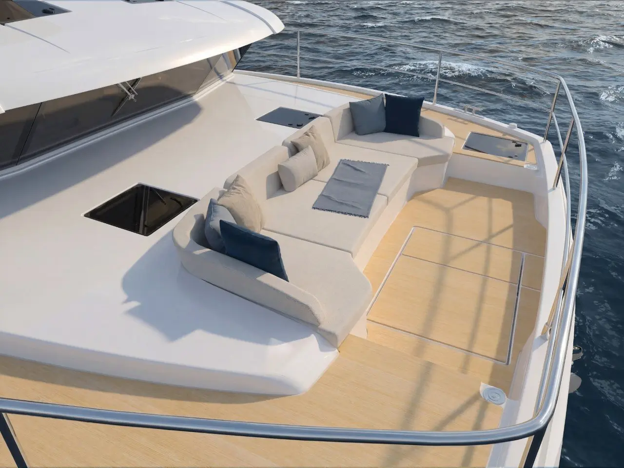 The foredeck from above, with sunpads and a hatch into the hull