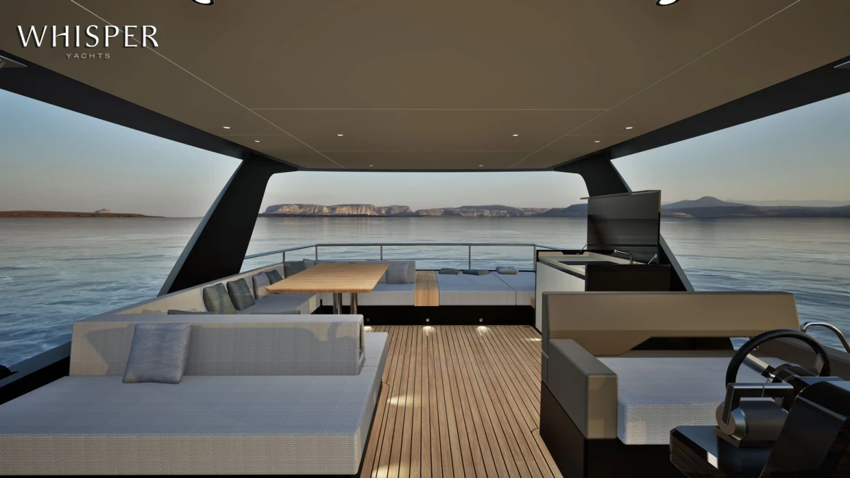 The aft cockpit under the hardtop, with a dining table and the helm to starboard