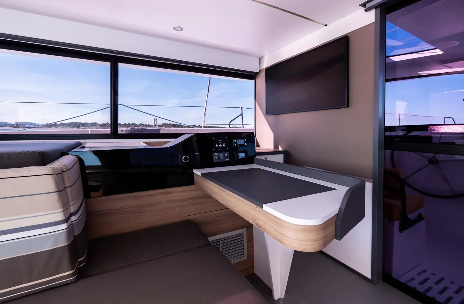A chart table and seat against a long hull window