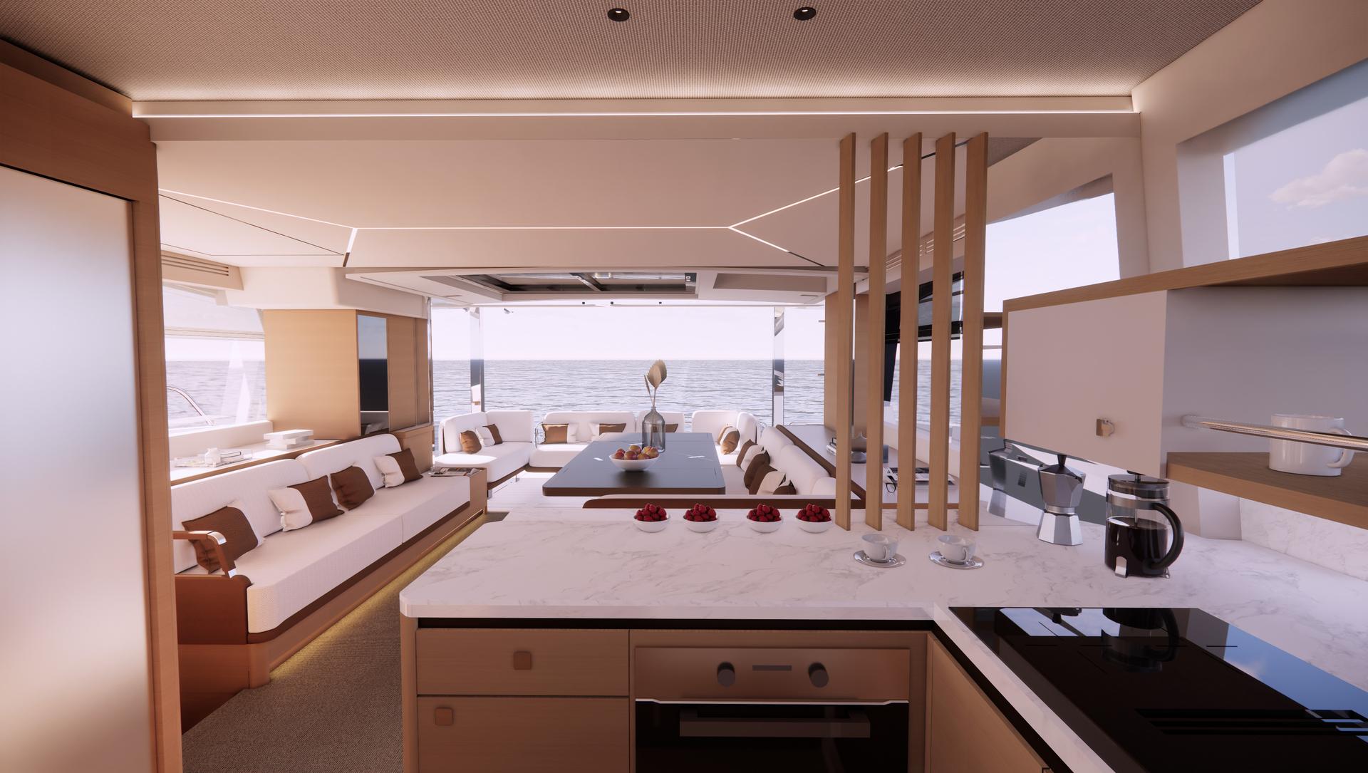 The YOT 53's saloon looking aft through the open cockpit to the sea, with a pale settee to one side, a dining table in the cockpit and a stone galley worktop in the foreground