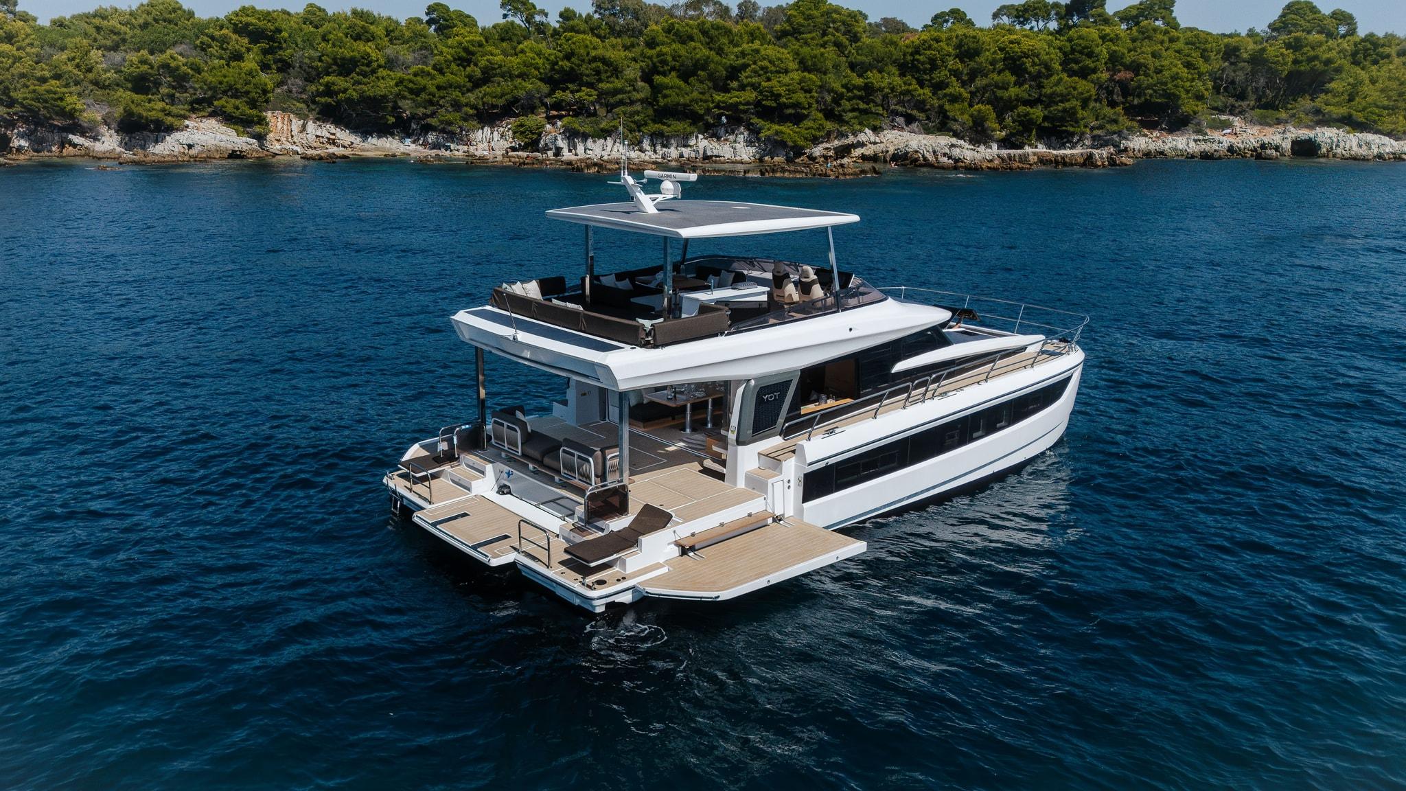 The YOT 53 at anchor seen from astern and above, the cockpit open to the fold-out terraces with the rooftop above
