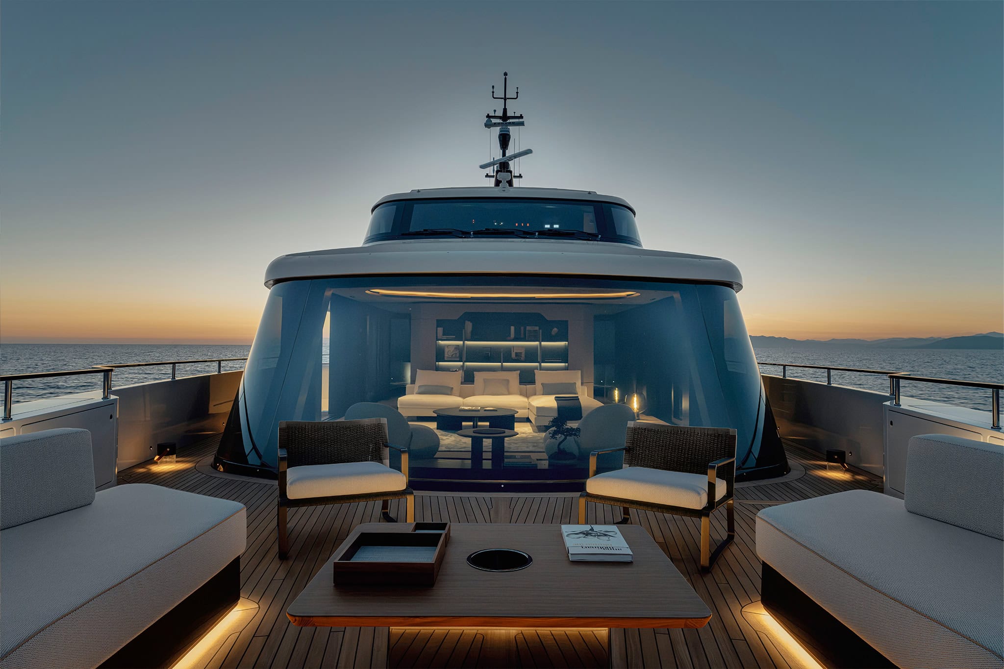 The forward lounge at dusk, behind the curved dark windscreen