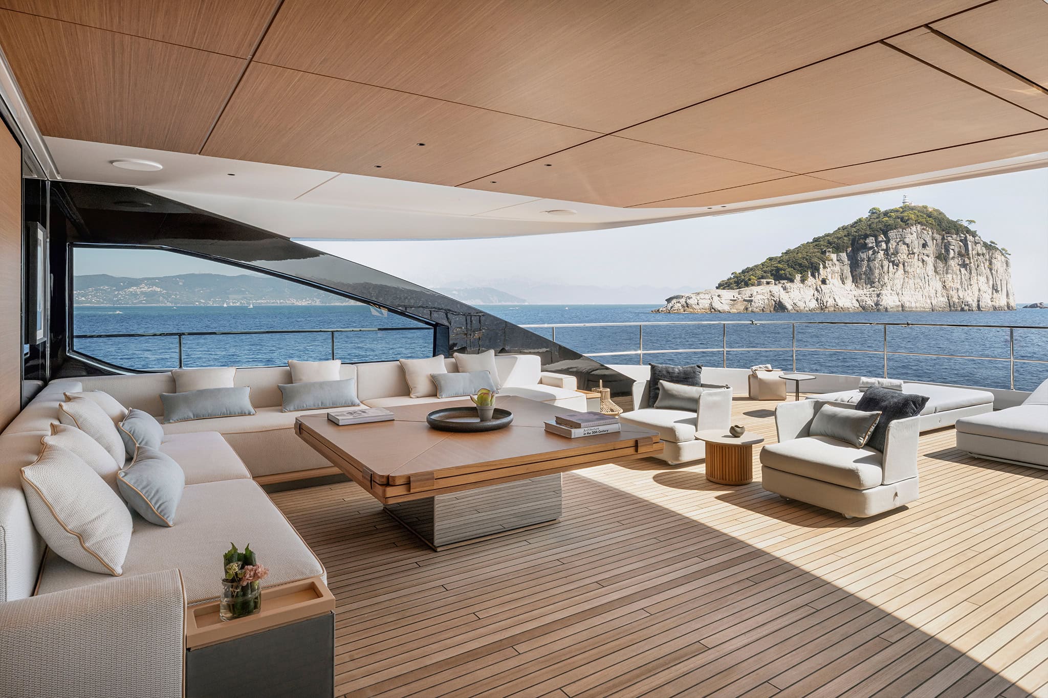 The bridge-deck lounge, open aft with a rocky island beyond