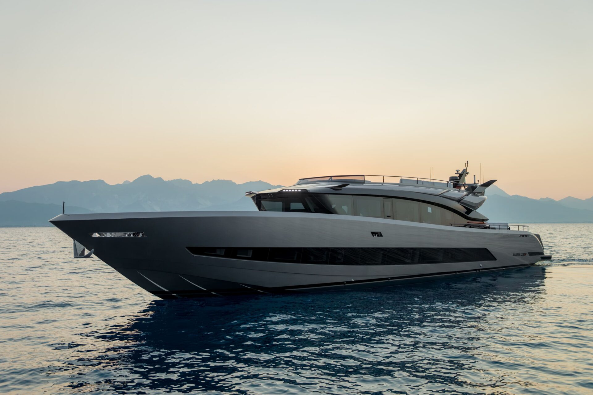 The BRABUS AB110 at rest at dusk seen from the bow quarter, BRABUS AB110 lettered on the hull side, mountains behind