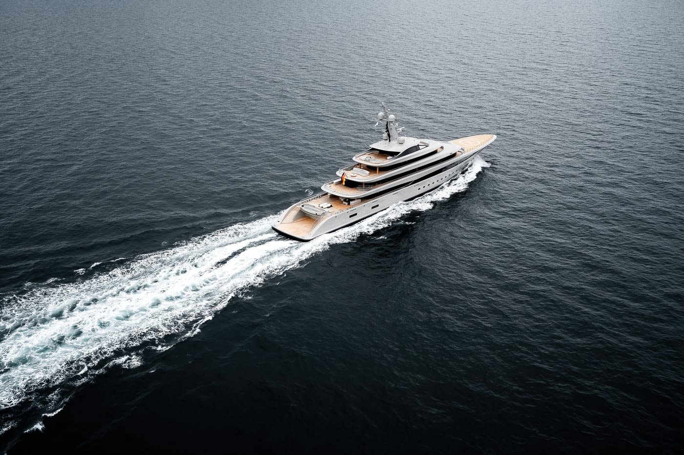 Nixie photographed from high above and astern, laying a long wake across dark water