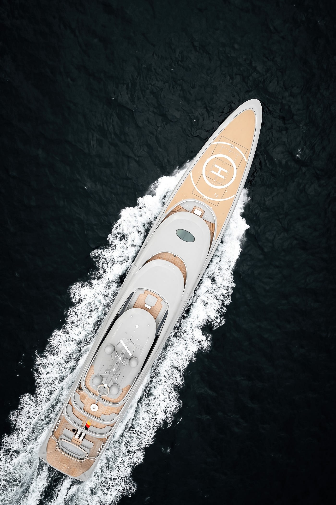 A straight-down view of Nixie under way, showing the helicopter circle forward and the full run of her teak decks