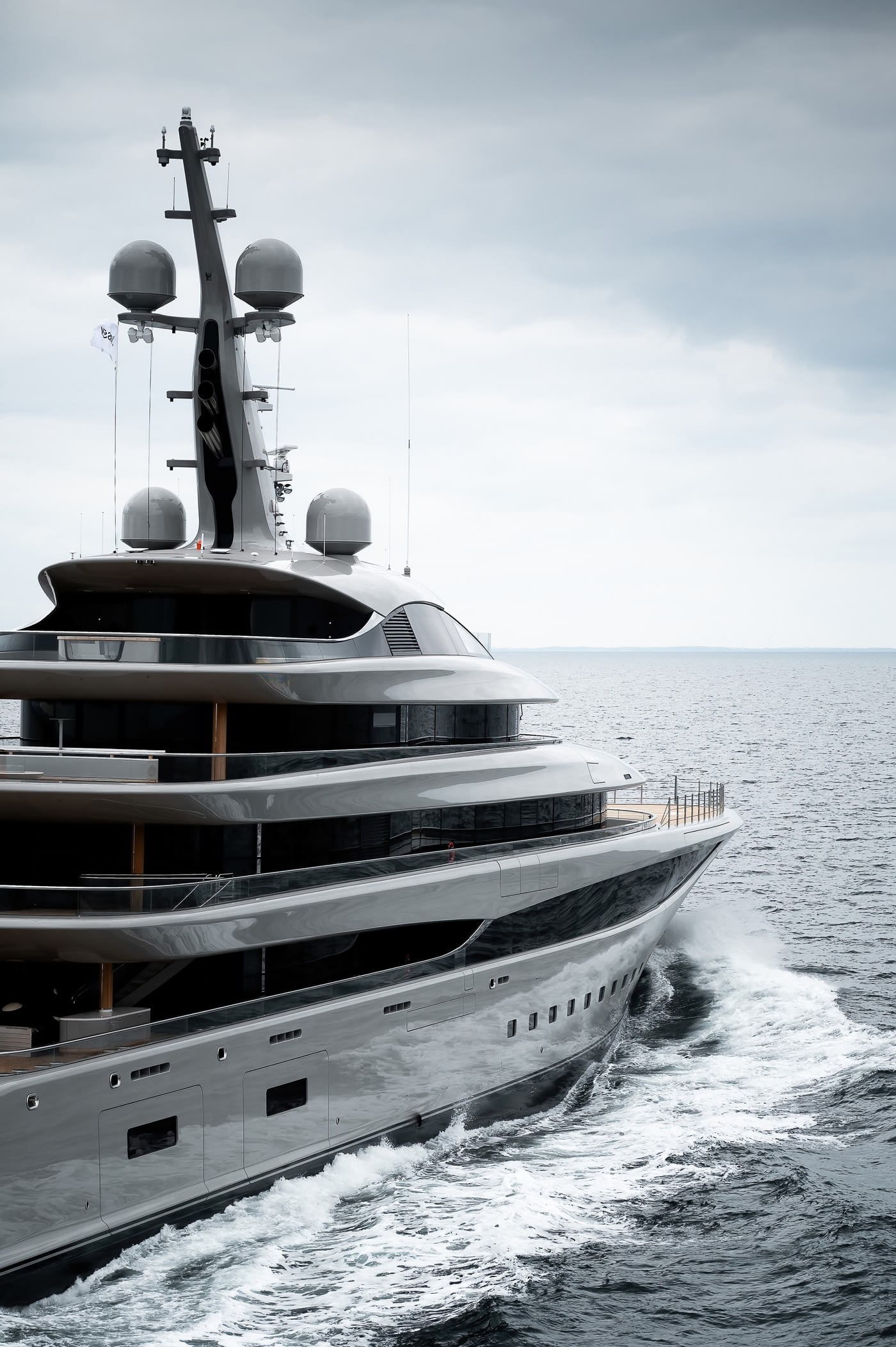 A close view of the stacked deck overhangs and the gradient-tinted glazing along her side