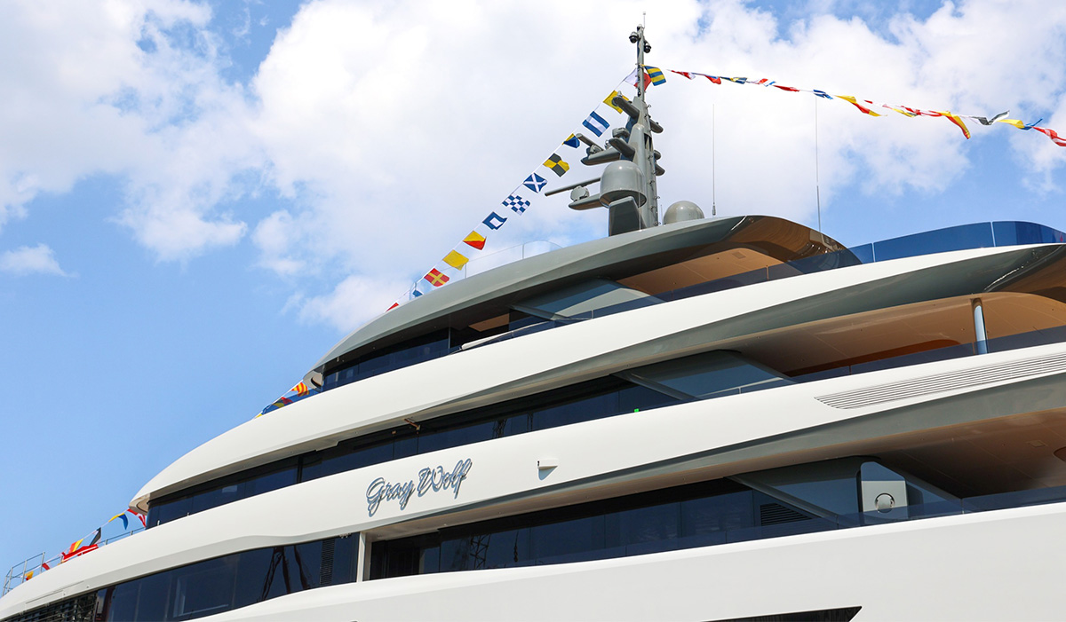 Gray Wolf's superstructure from below in daylight, her name in chrome script and signal flags running to the mast