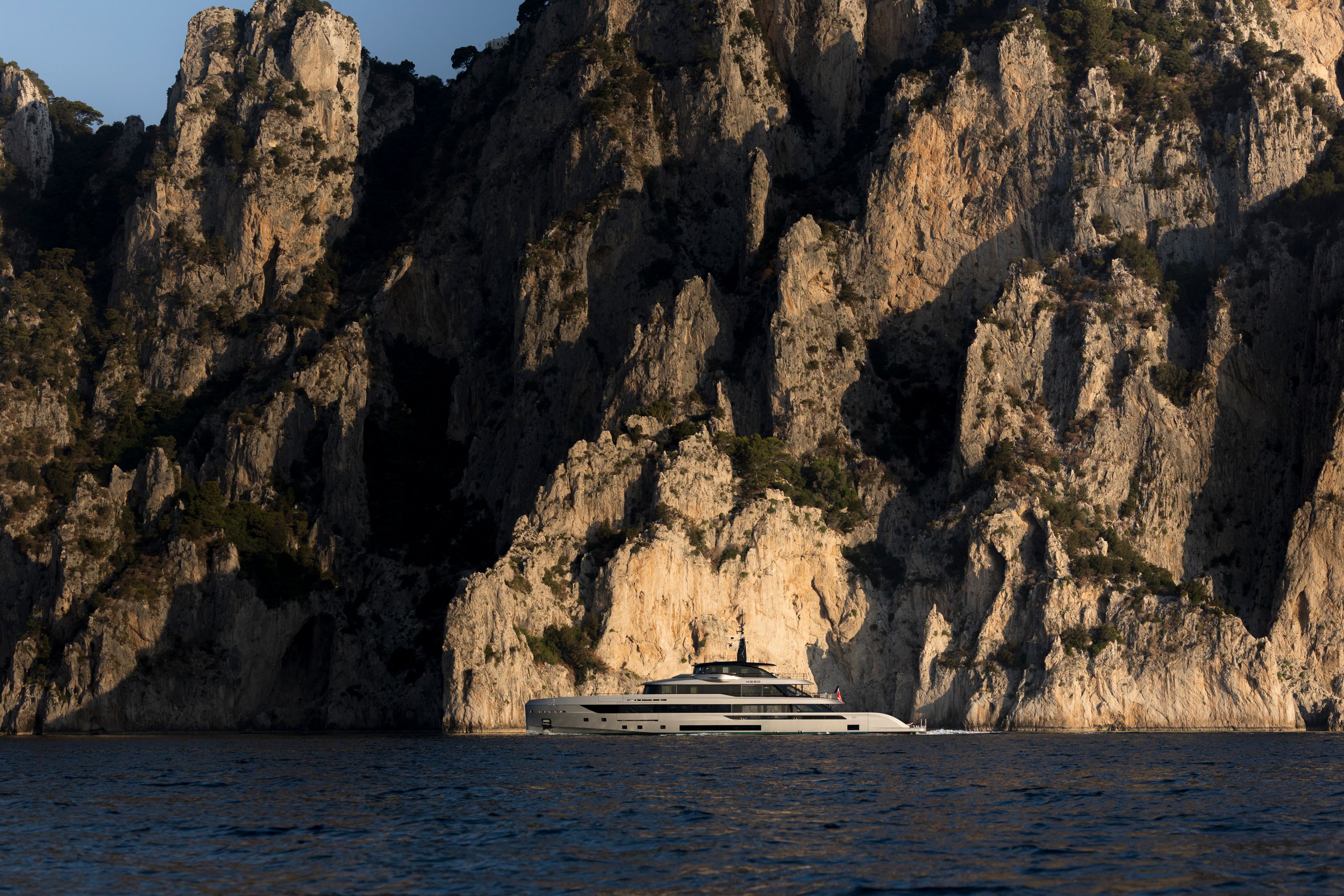 HEED running slowly beneath the limestone cliffs of Capri, tiny against the rock face