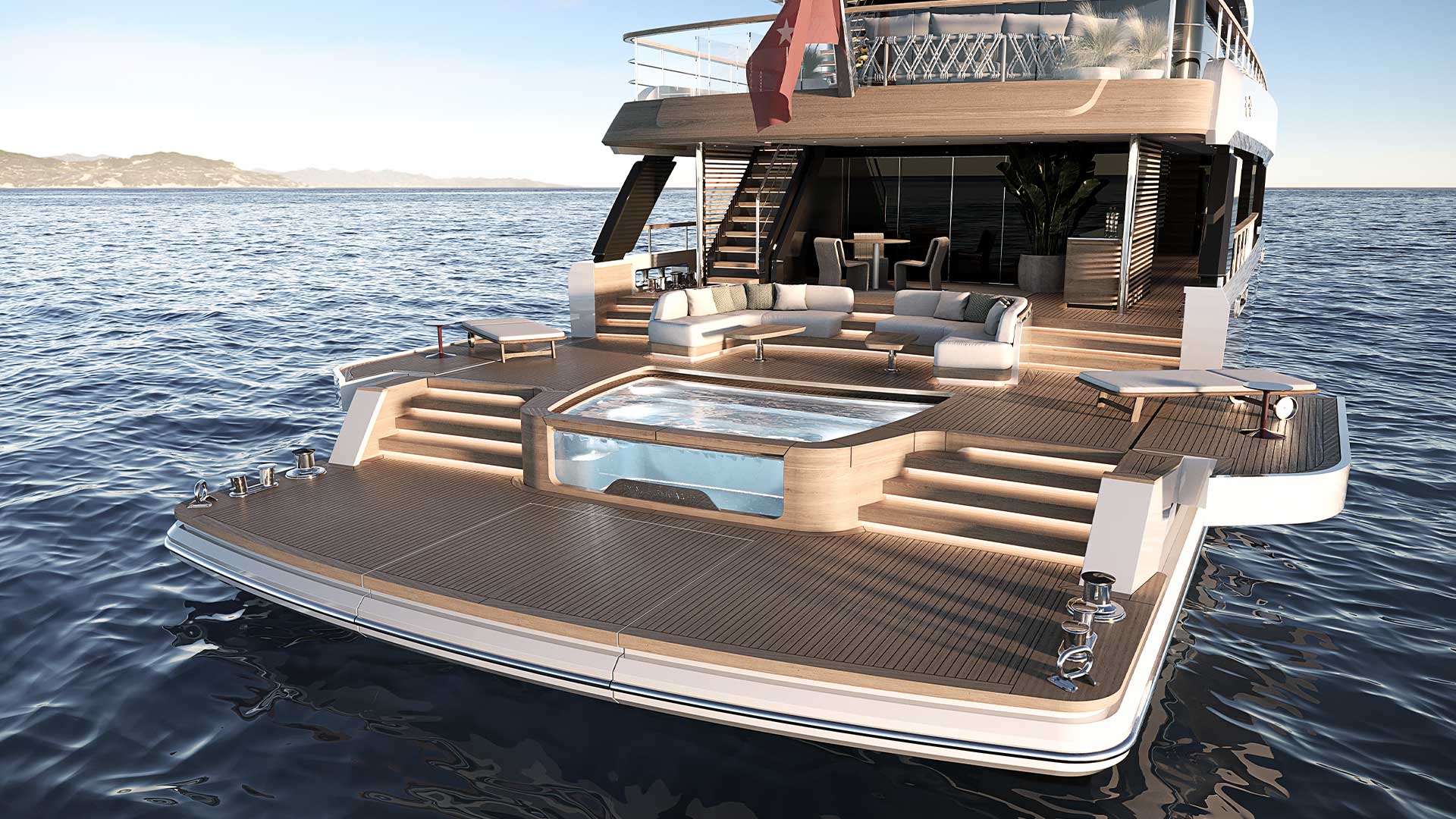 The aft deck and beach club, with a glass-sided pool set into teak and steps down to a wide bathing platform