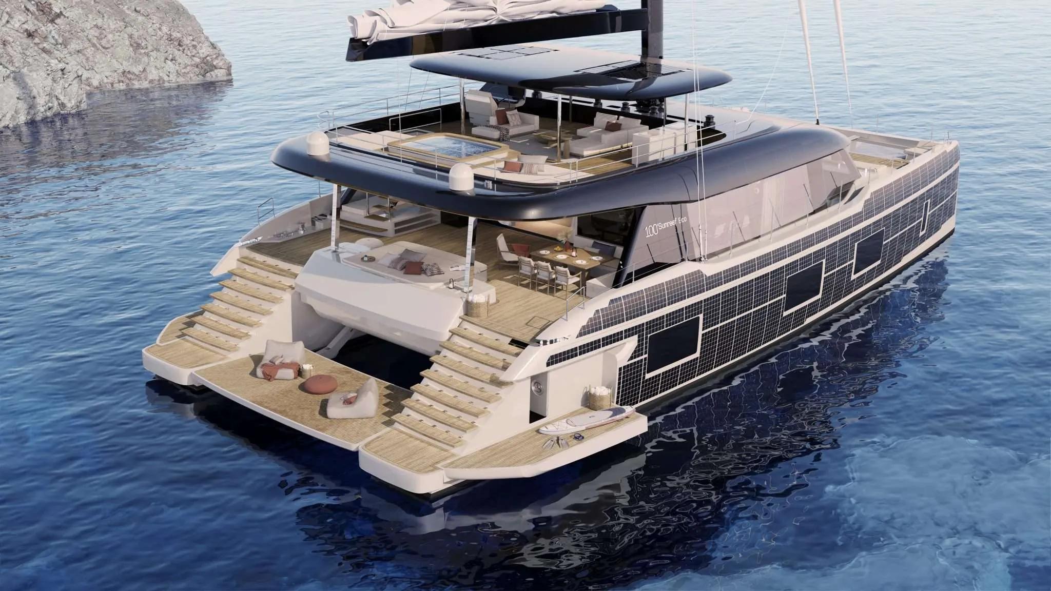 A Sunreef 100 Eco at anchor seen from astern and above, twin teak boarding stairs dropping to a beach platform, solar cells across the topsides