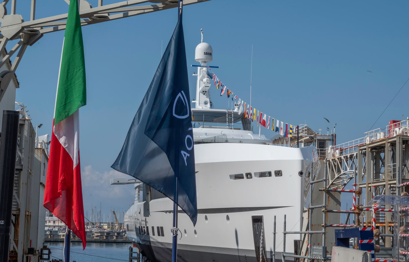 A photograph of Spirit's bow from the quay, an Italian flag and the Tankoa burgee in the foreground
